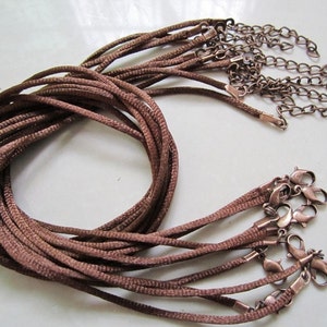 May include: A bundle of brown cords with metal clasps. The cords are approximately 18 inches long and are ideal for making necklaces or bracelets.