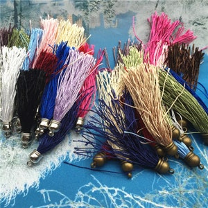 Può includere: Assortimento di frange colorate con cappucci metallici. Le frange sono realizzate con fili morbidi e fini e sono disponibili in una varietà di colori, tra cui rosa, blu, verde, marrone e nero.