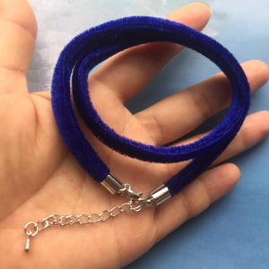 May include: A royal blue velvet choker necklace with a silver clasp and extender chain.