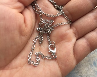 May include: A silver chain necklace with a lobster clasp.