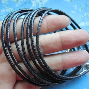 May include: A close-up of a bundle of black leather cord, showing the texture of the material. The cord is approximately 6mm wide and is suitable for jewellery making or other craft projects.