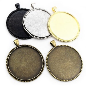 Puede incluir: Cuatro bandejas redondas de metal para colgantes con borde de cuentas. Las bandejas son de color negro, plateado, dorado y bronce.
