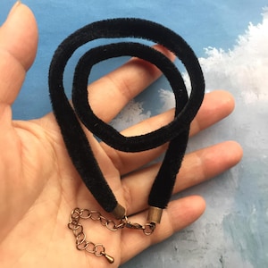 May include: A black velvet choker necklace with a gold-toned clasp.