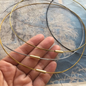 Puede incluir: Tres collares de color dorado con cierres dorados. Los collares están hechos de alambre fino trenzado.