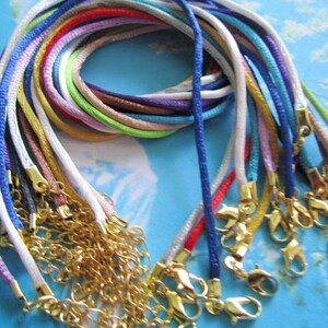Può includere: Una collezione di 18 cordoni colorati con chiusure dorate. I cordoni sono realizzati in un materiale morbido e setoso e sono perfetti per realizzare collane, braccialetti o altri gioielli.