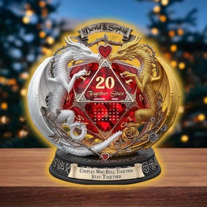 May include: A decorative sculpture with a red, gem-like die displaying the number 20 and the text "Together Since January 2005." Two dragons, one white and one gold, are on either side. The base reads "Couples Who Roll Together Stay Together."