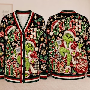 Può includere: Un cardigan nero con scollo a V caratterizzato da un motivo ripetuto del Grinch, alberi di Natale, regali e fiocchi di neve. Il testo "GRINCHY" appare in alto, mentre "NAUGHTY VIBES" e "STAY GRINCHY" sono stampati su tazze e borse.