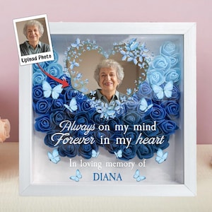 Może przedstawiać: Biała ramka na zdjęcie z niebiesko-białym układem kwiatowym w środku. Ramka ma miejsce na zdjęcie i tekst "Always on my mind Forever in my heart In loving memory of DIANA".