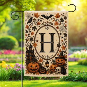 Könnte beinhalten: Eine rechteckige Gartenflagge mit einem zentralen Buchstaben H in einem ovalen Rahmen, umgeben von Herbstblättern, einer Krähe, einer Fledermaus, Spinnweben, einem Spukhaus, zwei Kürbissen, einem Totenkopf und einer schwarzen Katze.