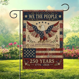 Puede incluir: Una bandera de jardín patriótica con un águila, estrellas y rayas en rojo, blanco y azul. La bandera dice "We the People" y "USA 250th Anniversary". Se muestra en un soporte de jardín de metal negro.
