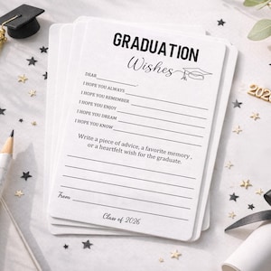 May include: A stack of white graduation wishes cards with lined spaces for messages. The cards have the text "GRADUATION Wishes" and "Class of 2026". A miniature graduation cap, pencil, and decorative stars are also present.