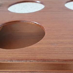 Op de afbeelding: Houten serveerblad met een chromen handvat en zes ronde uitsparingen. Het blad is gemaakt van lichtbruin hout met een gladde afwerking.