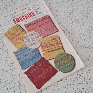 May include: A vintage book titled "Easy-on Smocking" with fourteen new designs. The book cover features colourful illustrations of different smocking patterns.