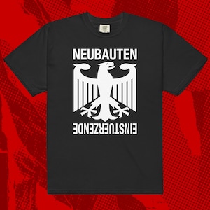 Puede incluir: Camiseta negra con un gráfico blanco de un águila estilizada y las palabras "NEUBAUTEN" y "EINSTUERZENDE" en letras blancas. La camiseta tiene cuello redondo y está hecha de un material suave.