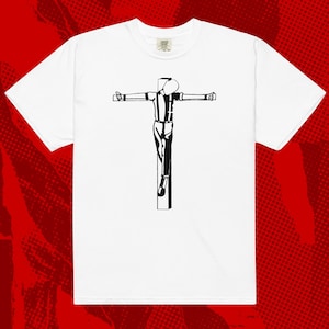 May include: White t-shirt with a black and white graphic of a person on a cross.
