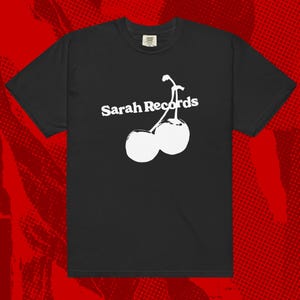 May include: Black t-shirt with a white graphic of two cherries and the text "Sarah Records".