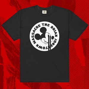Op de afbeelding: Zwart t-shirt met een witte afbeelding van Mickey Mouse en de tekst "Massacre The Brian Jonestown" in een cirkel. Het shirt heeft korte mouwen en een ronde hals.