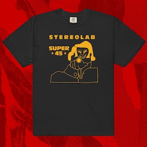 Peut inclure: T-shirt noir avec un motif jaune. Le motif présente le texte "STERELAB SUPER 45" et une illustration d'une personne pointant un pistolet. Le motif jaune est imprimé sur le devant du t-shirt.