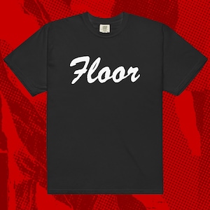 May include: Black t-shirt with the word "Floor" in white, cursive lettering. The shirt has short sleeves and a crew neck. The background is a red halftone pattern.