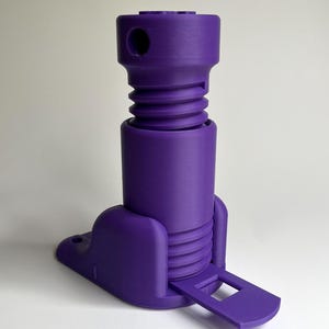 May include: A purple plastic footrest with a textured surface and a small, rectangular foot pedal. The footrest has a threaded design and a hole in the top.