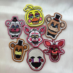 Puede incluir: Una colección de parches bordados con personajes de un popular videojuego. Los parches muestran varios personajes en colores vibrantes, incluyendo amarillo, marrón, rosa y rojo, con expresiones faciales detalladas y contornos.