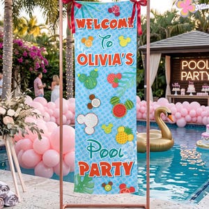 May include: A vertical rectangular banner suspended from a copper-colored metal frame. The banner features a light blue background with a repeating pattern of fruit-shaped icons and the text WELCOME TO OLIVIA'S POOL PARTY in red letters.