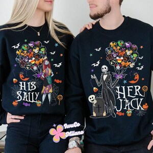 K&ouml;nnte beinhalten: Zwei passende schwarze Sweatshirts mit Halloween-Motiven. Eines zeigt Sally aus The Nightmare Before Christmas mit Ballons, dem Text "HIS SALLY" und Spinnweben. Das andere hat Jack Skellington mit Ballons, einem Grabstein und dem Text "HER JACK".