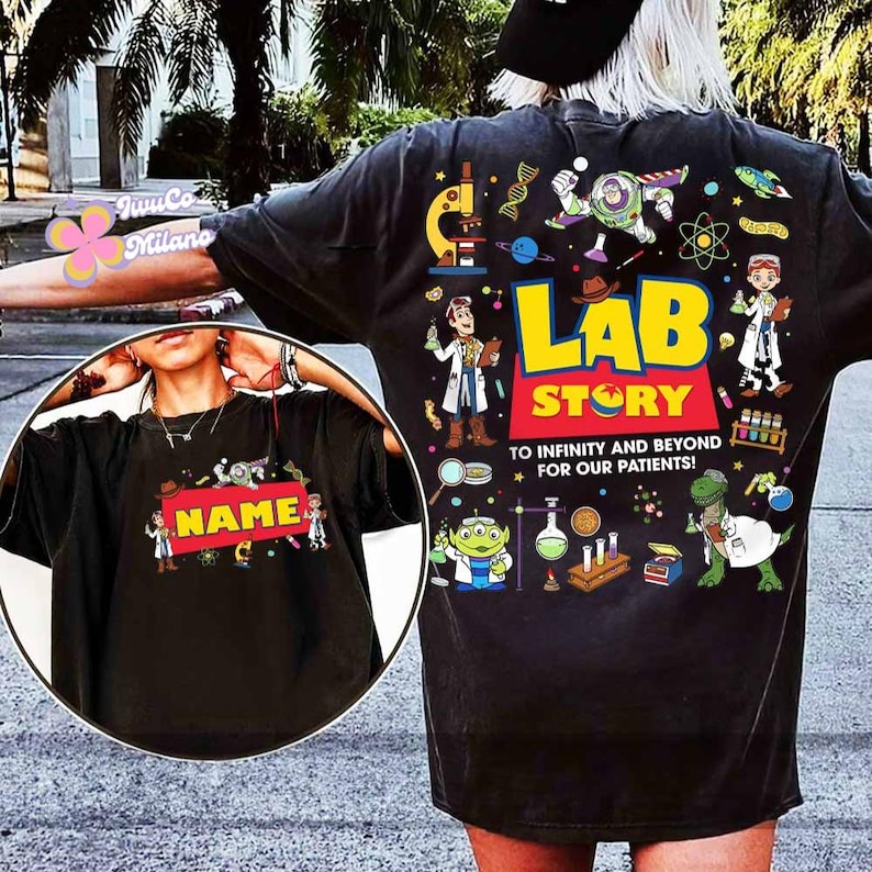 May include: Black t-shirt with a colorful "Lab Story" design featuring cartoon characters, lab equipment, and the text "To infinity and beyond for our patients!" A smaller image on the front has the word "NAME" on a red background.