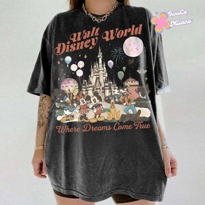 May include: Dark gray t-shirt featuring a graphic of the Walt Disney World castle, Mickey Mouse, Minnie Mouse, Donald Duck, Goofy, and Pluto. The text "Walt Disney World" and "Where Dreams Come True" are printed on the shirt.