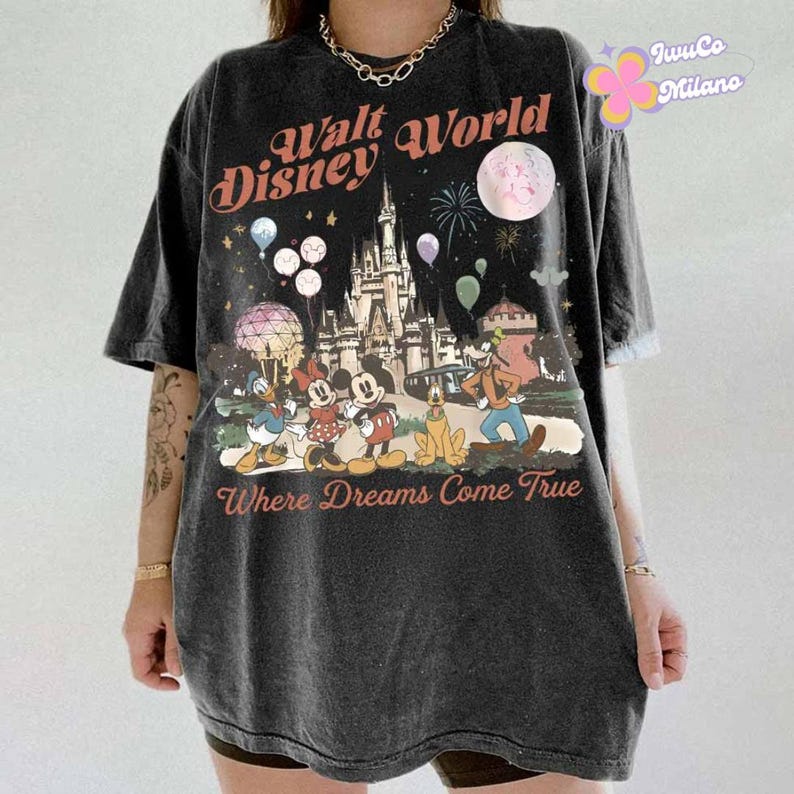 May include: Dark gray t-shirt featuring a graphic of the Walt Disney World castle, Mickey Mouse, Minnie Mouse, Donald Duck, Goofy, and Pluto. The text "Walt Disney World" and "Where Dreams Come True" are printed on the shirt.