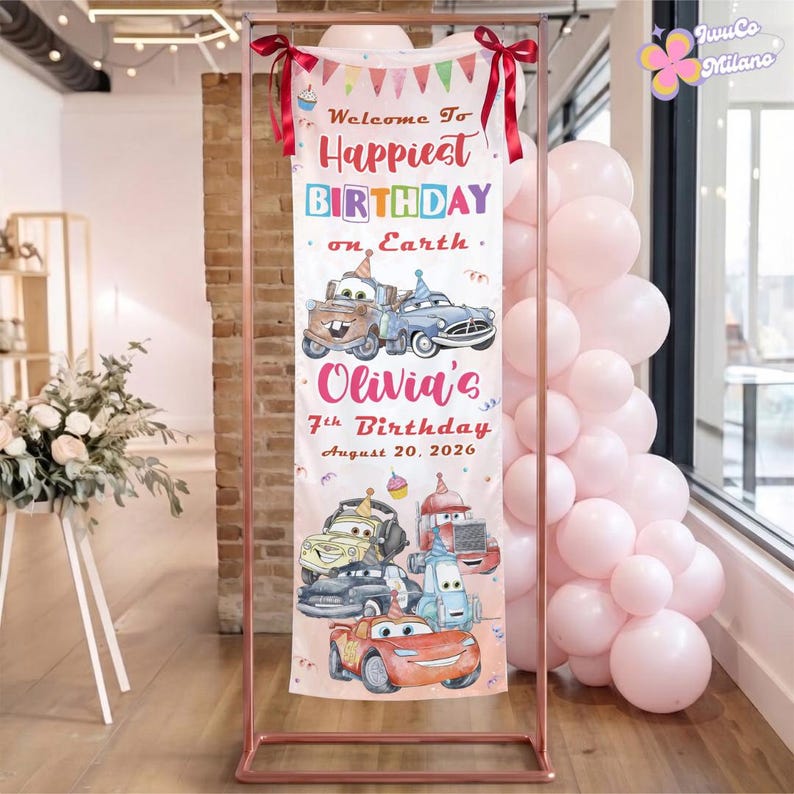 Op de afbeelding: Een verticale verjaardagsbanner met getekende raceauto's, kleurrijke vlaggetjes en de tekst Welcome To Happiest BIRTHDAY on Earth, Olivia's 7th Birthday, August 20, 2026. De banner staat op een koperkleurige metalen standaard met ballonnen.