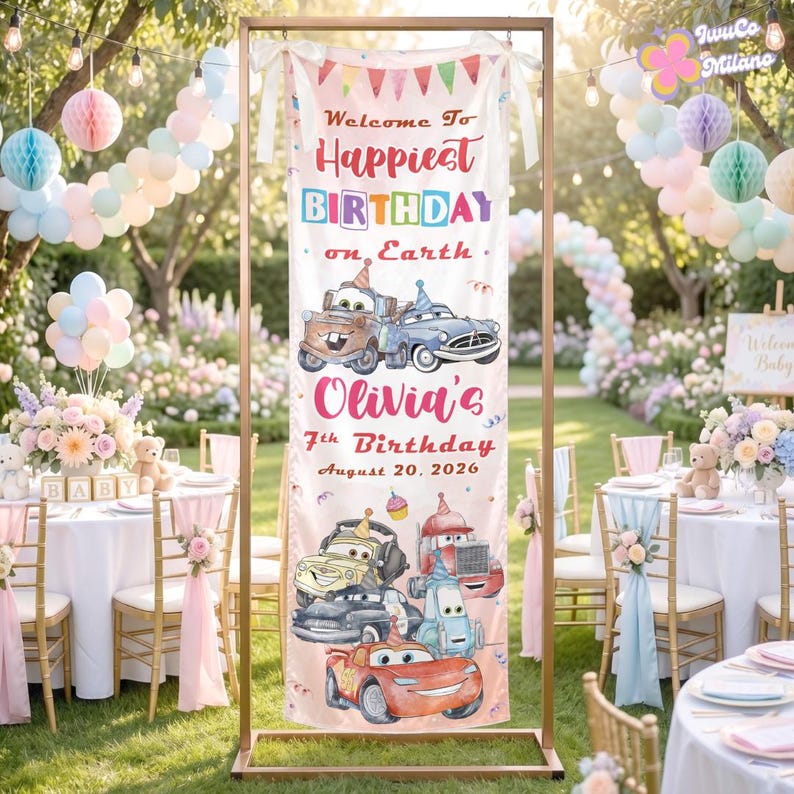 Op de afbeelding: Een verticale verjaardagsbanner met cartoon raceauto's en de tekst Welcome To Happiest BIRTHDAY on Earth Olivia's 7th Birthday August 20, 2026. De banner hangt aan een koperkleurig metalen frame in een buitenomgeving.
