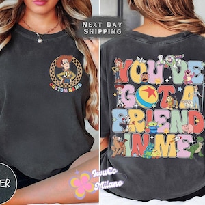 May include: A black t-shirt with a colorful graphic of characters from the Toy Story movie franchise. The graphic says "You've Got A Friend In Me" with the characters surrounding the text. The shirt also has a smaller graphic of Woody from Toy Story on the front.