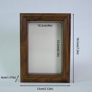 May include: A rectangular wooden picture frame with a brown finish. The frame is 13cm (5.12in) wide, 18.3cm (7.2in) tall, and 4cm (1.57in) thick. The inner dimensions are 10.2cm (4in) by 15.5cm (6.1in).