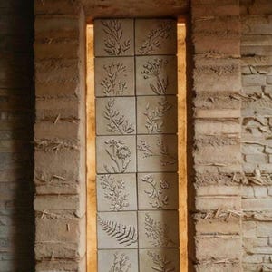 Può includere: Una tazza di ceramica bianca con manico nero e la scritta "But First, Coffee" in grassetto nero. La tazza è piena di un liquido scuro, probabilmente caffè, e poggia su una superficie chiara.