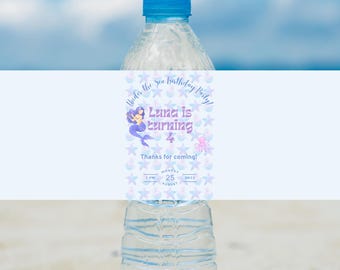 Peut inclure: Une bouteille d'eau bleue avec une étiquette qui dit "Under the Sea Birthday Party! Luna is turning 4. Thanks for coming! Monday, August 25, 1 PM - 3 PM". L'étiquette représente une sirène, des étoiles de mer et une pieuvre.