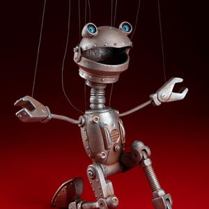 May include: A silver robot puppet with blue eyes and a wide smile, posed on one knee with its arms outstretched. The puppet is made of metal and has a steampunk aesthetic.