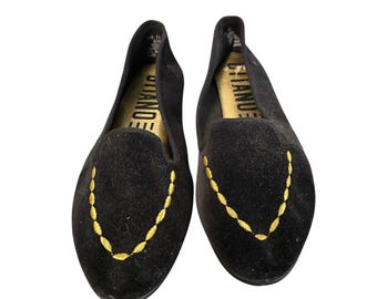May include: A pair of black velvet loafers featuring a pointed toe and a decorative gold embroidered chain-link pattern on the vamp. The interior footbed is gold-toned and displays the brand name CITANOE in bold black capital letters.