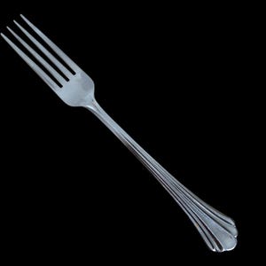May include: A stainless steel fork with four tines and a long, decorative handle. The handle features a series of parallel, curved lines that converge towards the end. The fork is set against a black background, highlighting its polished surface.