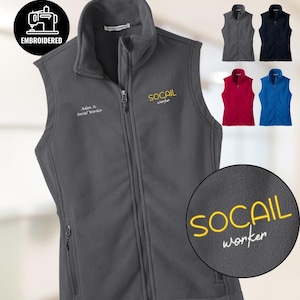 May include: A gray fleece vest with a full zipper, featuring embroidered text that reads "SOCAIL worker" in yellow and "Adam A. Social Worker" in white. Additional color options are displayed: gray, navy, red, and blue.