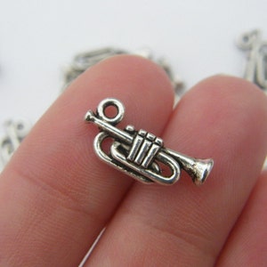 Puede incluir: Encanto de trompeta plateado con un diseño detallado. El encanto es perfecto para agregar un toque musical a las joyas o las manualidades.