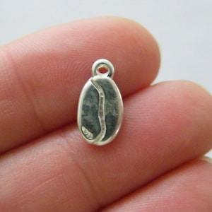 Puede incluir: Encanto de plata con forma de grano de café. El encanto tiene un diseño detallado y es perfecto para agregar un toque de fantasía a las joyas.