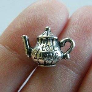 May include: Silver charm in the shape of a teapot with the words "tea time" on it.