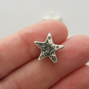 Puede incluir: Encanto de plata en forma de estrella con un diseño de espiral. El encanto de estrella mide aproximadamente 2,5 cm.