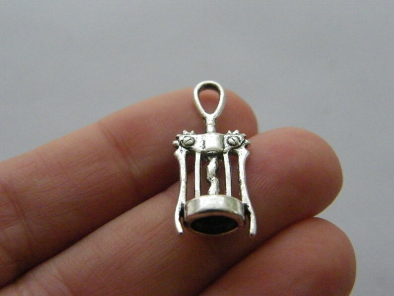 May include: Silver-toned metal corkscrew charm with a detailed design. The charm is small and would be perfect for jewelry making or crafting.