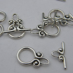Pu&ograve; includere: Chiusure in metallo argentato con disegni decorativi, perfette per la creazione di gioielli o progetti di artigianato.