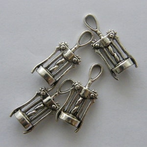 May include: Four silver-toned metal corkscrew charms. Each charm is a miniature replica of a traditional corkscrew.