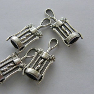 May include: Four silver-toned metal corkscrew charms. The charms are detailed with a corkscrew design and have a loop at the top for attaching to a necklace or bracelet.