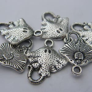 K&ouml;nnte beinhalten: Sechs silberfarbene Metall-Anh&auml;nger in Form von Stachelrochen. Die Anh&auml;nger haben eine strukturierte Oberfl&auml;che und eine &Ouml;se zum Anbringen an einer Halskette oder einem Armband.