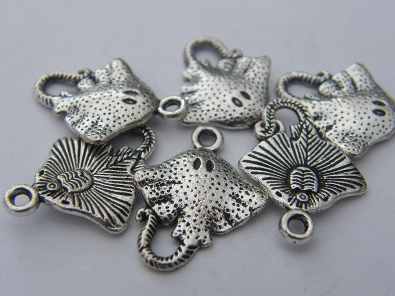 K&ouml;nnte beinhalten: Sechs silberfarbene Metall-Anh&auml;nger in Form von Stachelrochen. Die Anh&auml;nger haben eine strukturierte Oberfl&auml;che und eine &Ouml;se zum Anbringen an einer Halskette oder einem Armband.